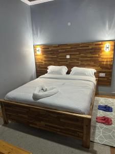a bedroom with a large bed with a wooden headboard at Posh lounge gardens in Gatimu