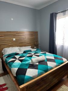 a bedroom with a bed with a checkered blanket at Posh lounge gardens in Gatimu