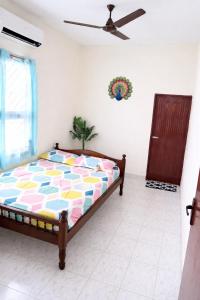 a bedroom with a bed and a ceiling fan at Vasan villa 2BHK in Pondicherry +2 photos
