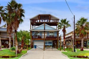 a large house with palm trees in front of it at Take Me To The Beach in Rockport