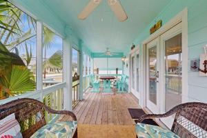 a porch with chairs and a piano on the beach at South Pearl Sailfish in Rockport