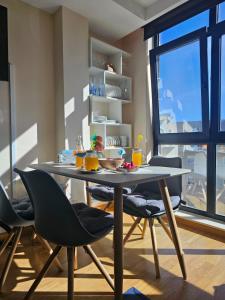 ein Esszimmer mit Tisch und Stühlen und einem Fenster in der Unterkunft Miño Beach in Miño