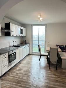 a kitchen with white cabinets and a table and a dining room at MühlengasseONE in Lenzing