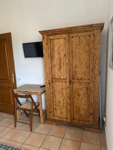 a wooden cabinet next to a table and a wooden desk at Relais Le Folaghe in Ladispoli