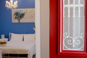 a red door with a bed in a room at IRIS Boutique Rooms in Korinthos