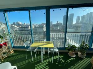 a yellow table and chairs on a balcony with a view at Mapo Panorama Stay in Seoul