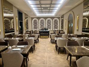 a restaurant with tables and chairs in a room at Aria Palace by OMNIA hotels in Rome +7 photos