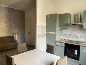 a kitchen with a white table and a couch at Alloggio Tommy in Biella