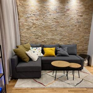 a couch with pillows on it in a living room at Ski-in Flat Next to Ski Road at Mountain View in Bansko