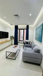 a living room with a couch and a table at Noble Rose Apartment in Kuwait
