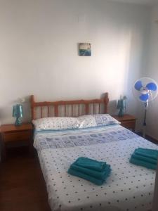 1 dormitorio con 1 cama y 2 toallas verdes en Mirador del Mediterraneo, en Villamartin