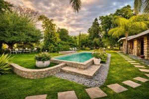a backyard with a swimming pool and a landscaped yard at Tarentaal Guest Farm Etosha National Park Namibia in Okaukuejo