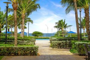 a pathway through a park with palm trees at Apartment in paradise on the happy island of ARUBA, beachfront in Savaneta