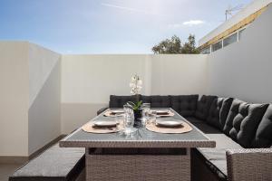 a table with plates and wine glasses on a patio at Lusomare By Marenssa in Moncarapacho