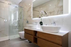 a bathroom with two sinks and a shower at Lusomare By Marenssa in Moncarapacho +8 photos