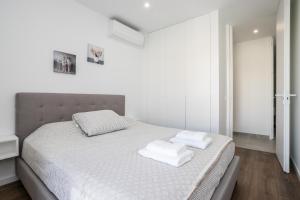 a bedroom with a bed with two towels on it at Lusomare By Marenssa in Moncarapacho