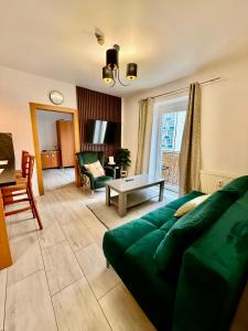a living room with a green couch and a table at Aura centrum in Piešťany