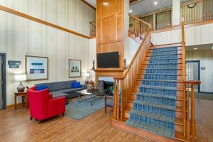 a living room with a staircase and a couch at Country Inn & Suites by Radisson, Jacksonville West, FL in Jacksonville