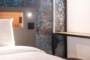 a bedroom with a bed and a mirror at Kyriad Argenteuil in Argenteuil