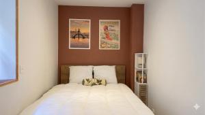 a bedroom with a bed with two posters on the wall at KENDALL in Saint Malo