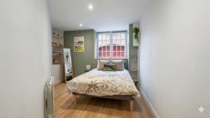 a bedroom with a bed and a window at KENDALL in Saint Malo