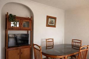 a dining room with a table and a tv at Apartamento en Xeraco in Xeraco