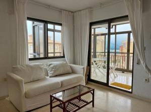 a living room with a couch and a glass table at Apartamento en Xeraco in Xeraco