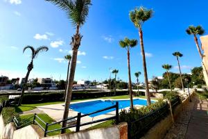 a pool with palm trees in a resort at Spacious Triplex in Harhoura in El Harhoura
