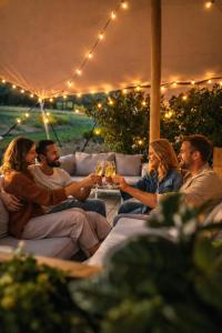 a group of people sitting around a table with drinks at Le Domaine de Bra in Bra