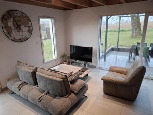 a living room with two couches and a tv at gîte les bouleaux in Carspach