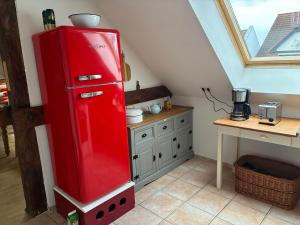 a red refrigerator in a kitchen with a table at Beim Schlangenkönig in Straupitz