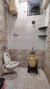a bathroom with a toilet and a sink at Hotel Rayas in Kumbakonam +20 photos