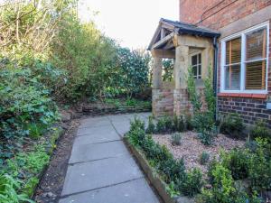 a garden in front of a brick house at Cheshire Views in Malpas