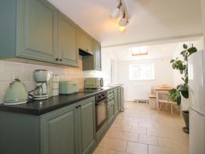 a kitchen with green cabinets and a counter top at Cheshire Views in Malpas