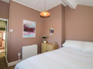 a bedroom with a white bed and a pink wall at Cheshire Views in Malpas