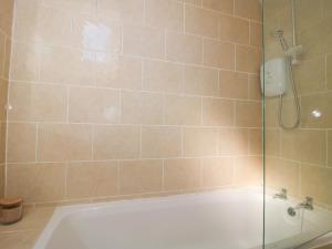 a bathroom with a shower with a white tub at Cheshire Views in Malpas +19 photos