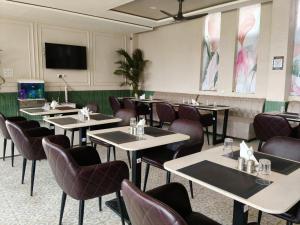 a restaurant with tables and chairs and a flat screen tv at IR Resorts Mahasamund in Mahāsamund