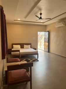 a room with two beds and a chair in it at IR Resorts Mahasamund in Mahāsamund