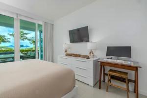 a bedroom with a bed and a desk with a computer at Apartment in paradise on the happy island of ARUBA, beachfront in Savaneta
