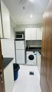 a small kitchen with a stove and a dishwasher at Noble Rose Apartment in Kuwait