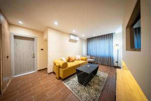 a living room with a yellow couch and a table at B Suites Boutique Hotel in Amman