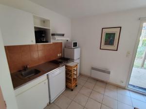 a small kitchen with a sink and a microwave at Village Vacances La Manne in Bormes-les-Mimosas +29 photos