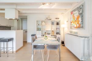a dining room with a white table and chairs at Aalduiker 7 in Nieuwpoort