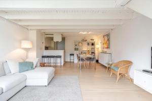 a living room with a white couch and a table at Aalduiker 7 in Nieuwpoort +13 photos