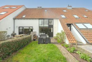 a white house with windows and a yard at Aalduiker 7 in Nieuwpoort