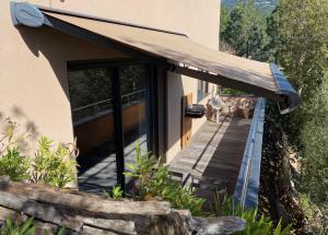 a building with awning next to a wooden walkway at Résidence Petru-Maria in Propriano