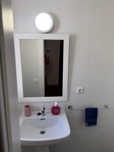 a bathroom with a white sink and a mirror at Casa de la playa in Oropesa del Mar +16 photos