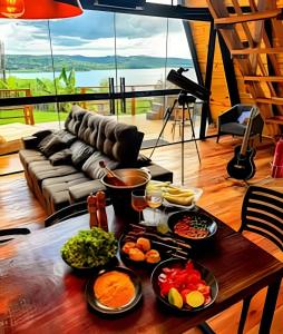 a table with many plates of food on it at Lakefront Chalet, hot tub, heated bathtub and waterfall in Alexânia