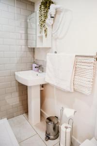 a white bathroom with a sink and a mirror at Robyns Retreat in Brynsiencyn