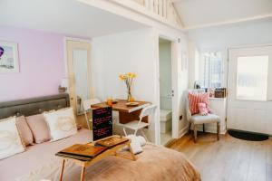 a bedroom with a bed and a table and a desk at Robyns Retreat in Brynsiencyn